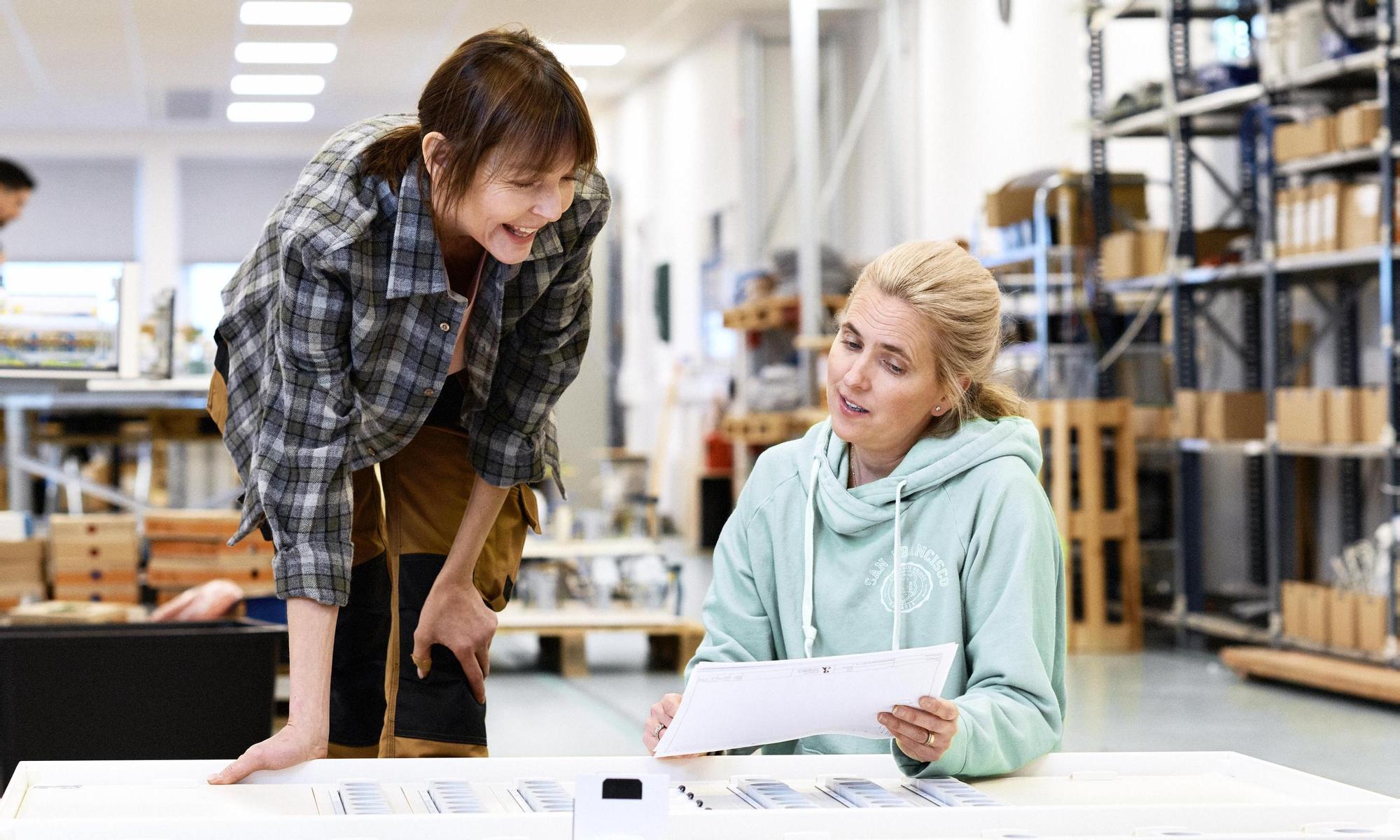 Two colleagues where one shows information on a paper